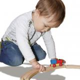 Kind spielt mit einer Holzeisenbahn